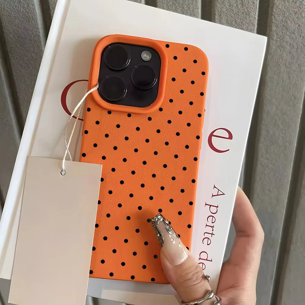 An orange polka dot textured phone case with a soft-touch grip is displayed next to a white card.