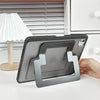 A gray protective case for a tablet or iPad is shown resting on a white surface next to a lamp and a kitchen cabinet.