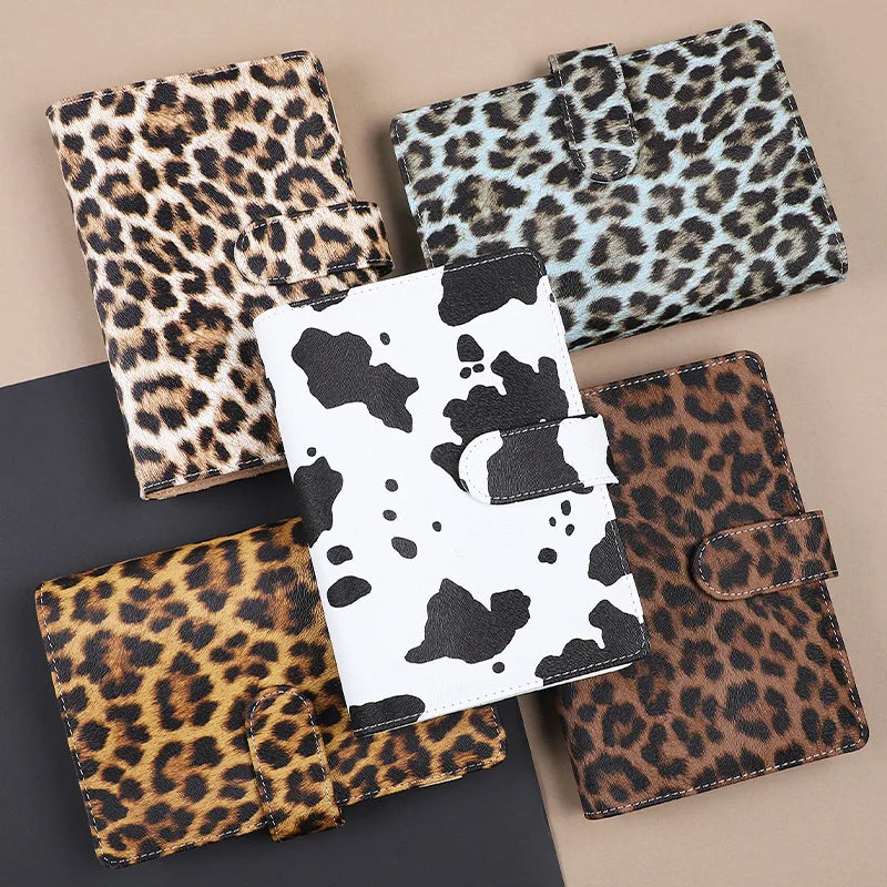 A collection of leopard print binders and folders in various shades of brown, black, and white.