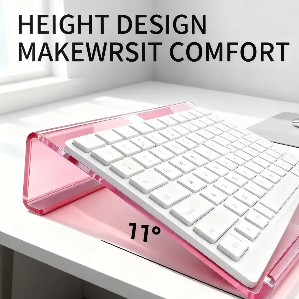 A pink acrylic keyboard riser stand featuring a white keyboard and an ergonomic wrist rest, shown at an angle.