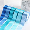 Roll of satin ribbon in various shades of blue and teal for gift wrapping or crafts