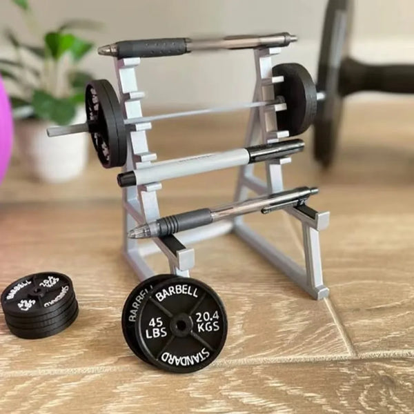 A silver barbell rack organizer with pen holders and a barbell resting on a wooden surface.