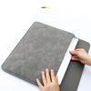 Eine Hand öffnet eine graue PU-Leder-Laptophülle und demonstriert ihre Passform und das Design.