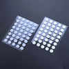 A pack of universal mouse skates with adhesive glide feet arranged on a dark surface.