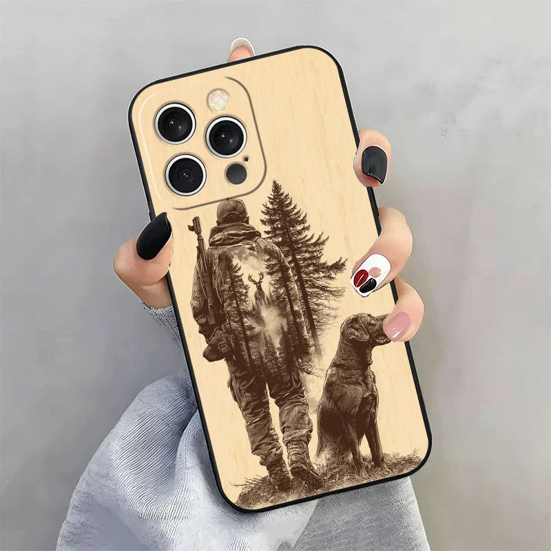 A beige silicone phone case for an iPhone featuring a silhouette of a hunter and a dog against a forest background.