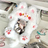 A white fluffy plush holder designed to display a K-pop photocard, featuring pink paw prints and small decorative elements.
