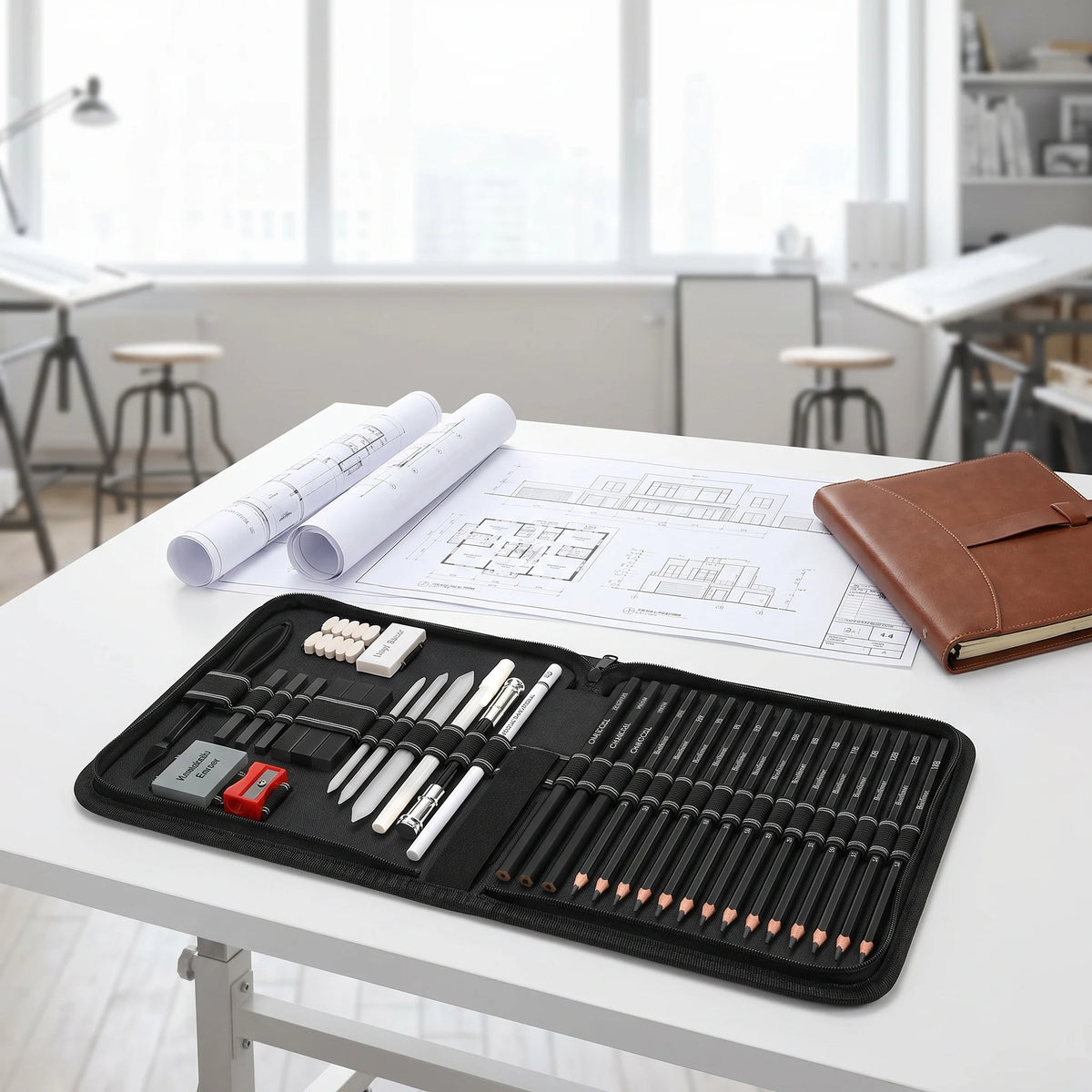 Professionelles Zeichenset mit Graphit- und Kohlebleistiften auf weißem Tisch.