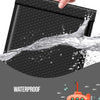 Eine Hand presst einen schwarzen Honigbehälter, der seine wasserdichte Eigenschaft demonstriert, mit Wasser, das spritzt.