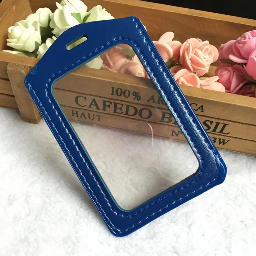 A blue PU leather ID card holder with a lanyard is placed inside a wooden box surrounded by pink roses.