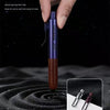 Una mano sostiene una clip de bolígrafo de metal morado oscuro con agarre de madera, mostrando su diseño fácil de llevar.