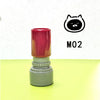 A red and gray teacher stamp with a cat face design is shown on a yellow surface.