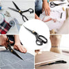 A collection of professional stainless steel tailor scissors and a fine point tool on a wooden surface.