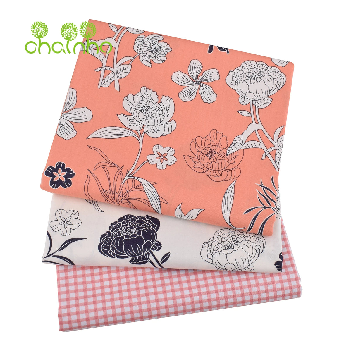 Gestapelte Twill-Baumwollstoffe mit Blumenmustern in Pfirsich-, Weiß- und Rosatönen.