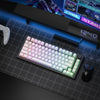 A close-up view of a purple and white mechanical keyboard with custom keycaps resting on a dark surface next to a gaming mous