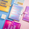 Eine Sammlung farbenfroher Umschläge und Ordner in Gelb, Pink und Lila werden auf einer hellen Oberfläche präsentiert.