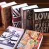 A collection of vintage-style books with textured covers and patriotic themes, including a dictionary safe for keys and valua