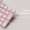 A close-up view of pink translucent ice crystal mechanical keycaps arranged in a keyboard layout.