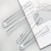 A set of precision acrylic folding rulers and measuring tools laid out on a white background.