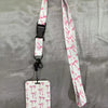 White lanyard with pink floral pattern attached to an ID badge holder.