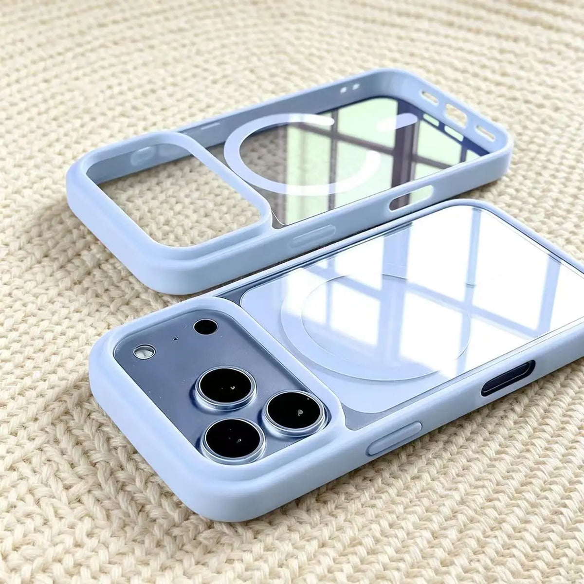 A light blue transparent acrylic phone case with a clear back and a protective frame is shown on a beige textured surface.