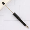 A black DIY beadable pen with a gold tip and a long metal shaft is shown on a white tiled surface.