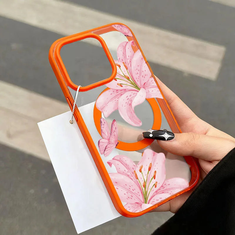 An orange transparent phone case featuring a pink lily floral design held in a hand.