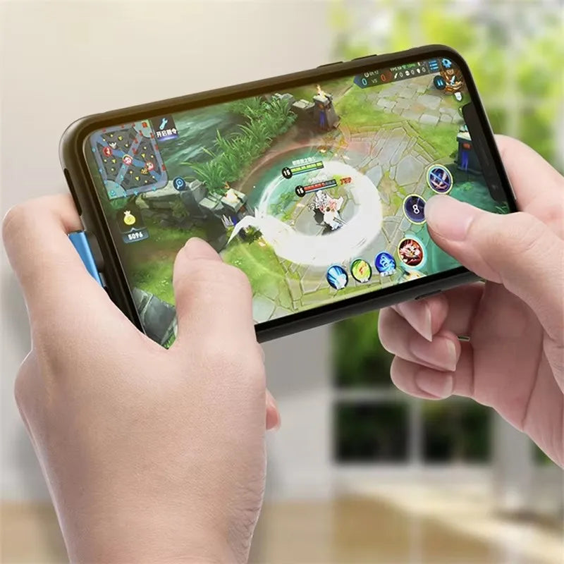 A hand holds a smartphone displaying a mobile game, with a braided USB charging cable visible.