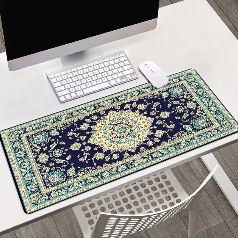 A dark blue vintage Persian rug gaming mouse pad with intricate gold and teal patterns on a white desk.