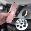 A hand holds a pink smartphone attached to a magnetic mount designed for a car dashboard.