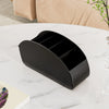A black acrylic remote control holder and desk organizer tray resting on a white marble surface.