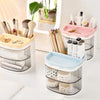 A set of clear acrylic desktop pen holders with various brush and cosmetic tools in pink, beige, and blue colors.