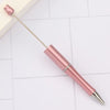 A pink DIY beadable pen set with a silver tip and gold accents resting on a white surface.