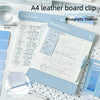 A close-up of an A4 leather clipboard with a blue magnetic closure and contrast stitching on a white background.