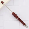 A DIY beadable pen set with a metallic silver body and a dark red, textured barrel is shown on a white surface.