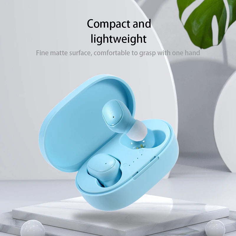 Auriculares inalámbricos Bluetooth azul claro en un estuche compacto sobre una superficie blanca.