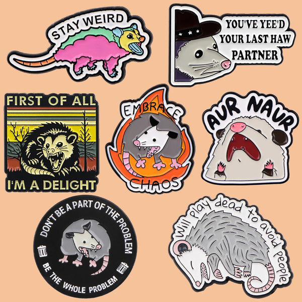 A collection of enamel pins featuring humorous phrases like Stay Weird I'm a Delight and Don't Be Part of the Problem