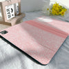 Pink composition book cover with a textured pattern and a pencil holder resting on a white sheet.