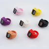 A collection of colorful thumb tally counters in various colors including pink, yellow, purple, white, black, and red.