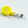 Porta credencial de plástico amarillo con tarjeta de plástico transparente y clip metálico.