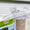 A close-up of frosted transparent book page clips used to hold a paper page in place.