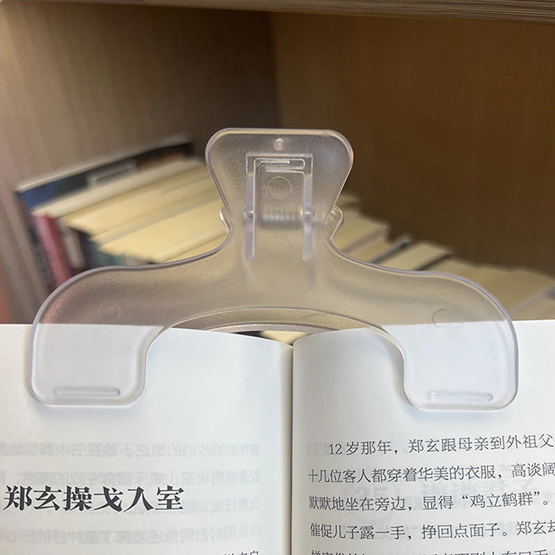 A close-up of clear plastic book page clips used to hold pages together in a book.