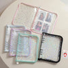 A transparent zipper photo binder with multiple clear plastic pages and a pink and green colored cover.
