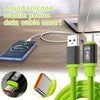Flüssiges Silikon-Mobiltelefon-Datenkabel und Ladegerät mit grünen und schwarzen Komponenten auf einem Holzschreibtisch.