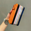 A hand holds a stack of colorful, textured phone cases with shockproof protection.