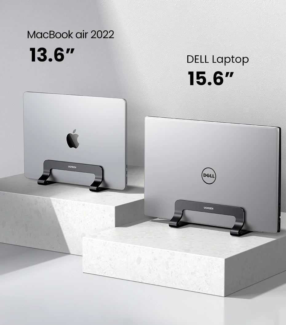 A comparison of a MacBook Air 2022 and a Dell laptop displayed on vertical stands.