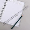 A transparent folding ruler and a pencil are placed on a spiral-bound notebook page.