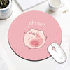 A pink cartoon pig face with an expression of surprise is printed on a round mouse pad next to a computer mouse.