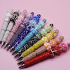 A collection of handmade acrylic flower beads in various colors and shades arranged diagonally.