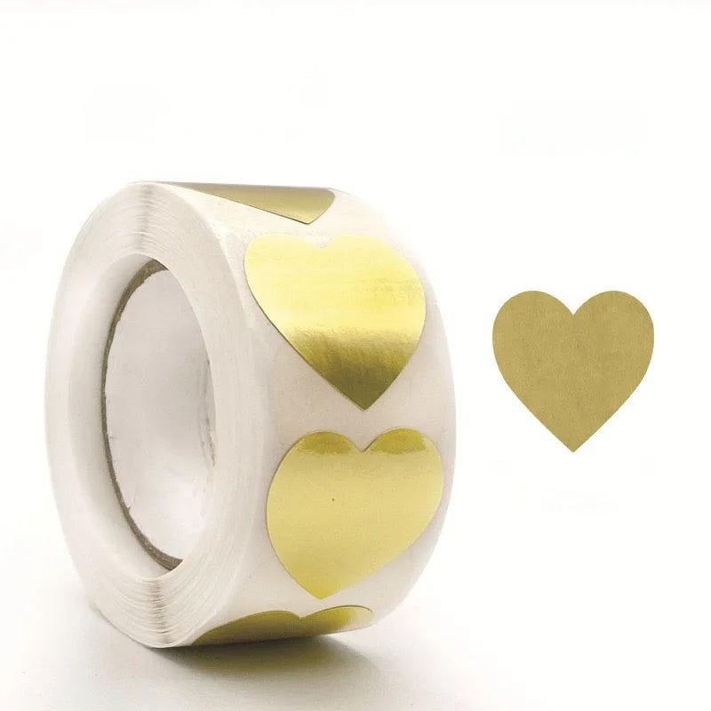 A round roll of kraft paper self-adhesive labels with three gold heart-shaped stickers attached.