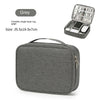 A grey portable single-layer lug-gage travel cable organizer bag with a lid showing various electronic accessories.